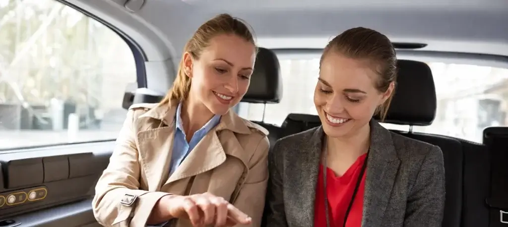 Professional women collaborating in luxury car
