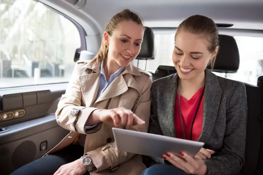 businesswomen discuss strategy while driving to business meeting