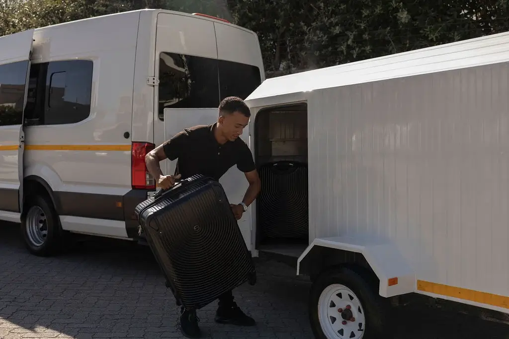 Chauffeur loading luggage into trailer